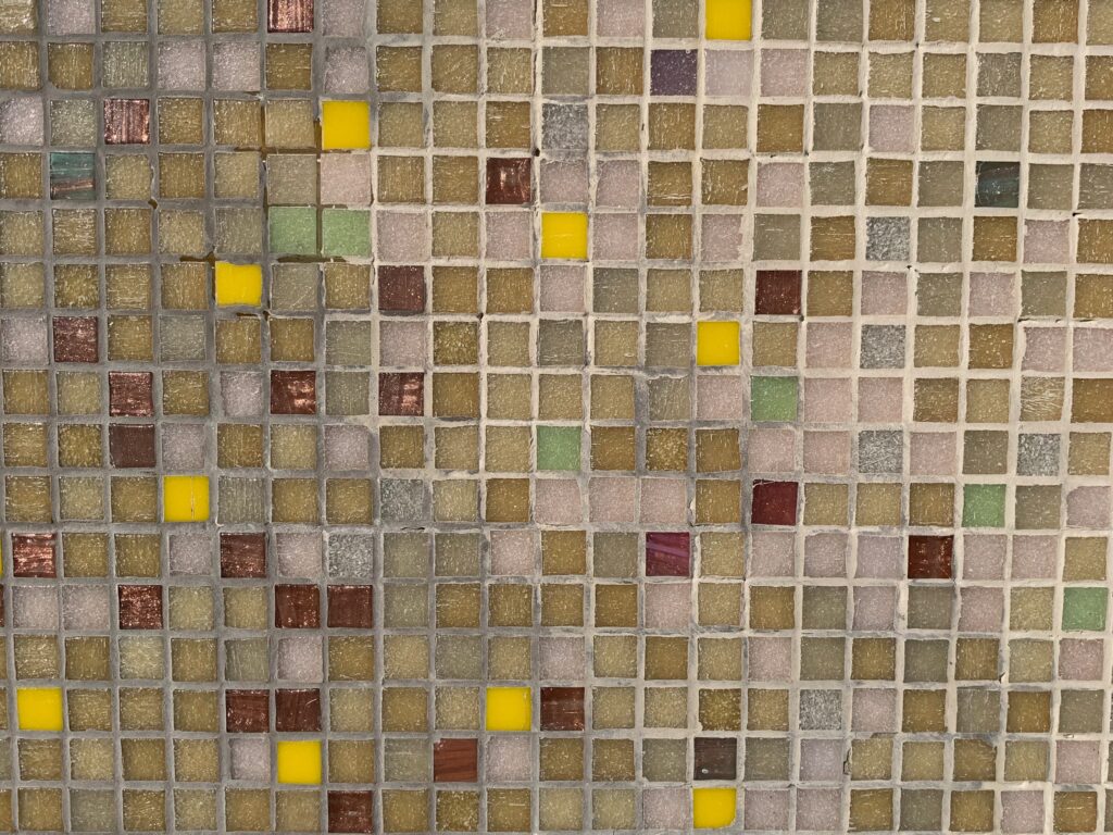 Bright yellow, dark red and pink mixed into brown grid of ceramic tiles