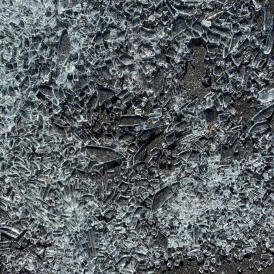 Charcoal gray concrete pavement covered in shattered glass