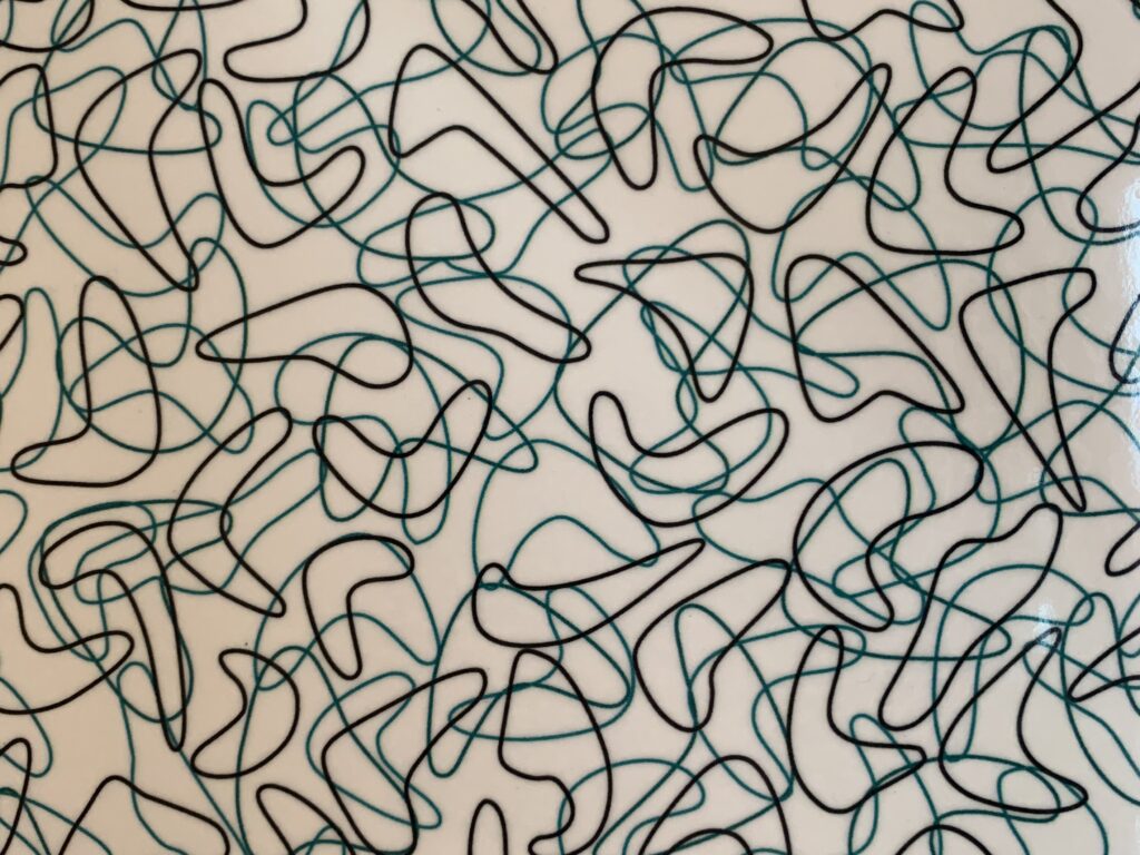 Squiggly black and green lines printed on white plastic